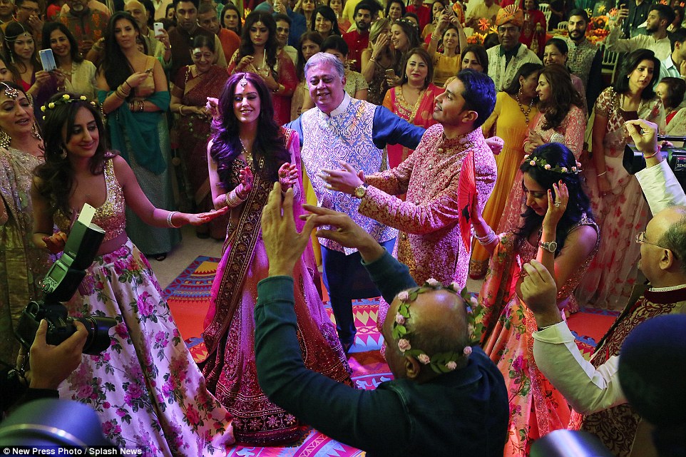 Guests wore traditional Indian dress, with the bride and groom taking centre stage in front of groom's father Yogesh Mehta (centre in blue)