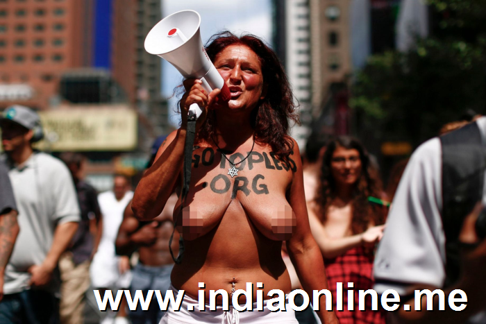 A woman uses a megaphone as she bares her naked chest in the GoTopless pride parade in Manhattan August 23, 2015 in New York City