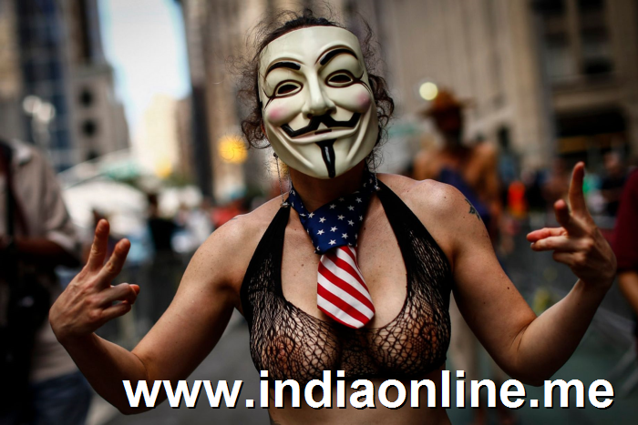 A woman wears a mask as she bares her chest in the GoTopless pride parade in Manhattan August 23, 2015 in New York City