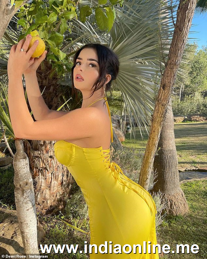 Working it: The social media star displayed her peachy posterior in the figure-hugging dress by PrettyLittleThing, as she held onto a lemon hanging on a tree